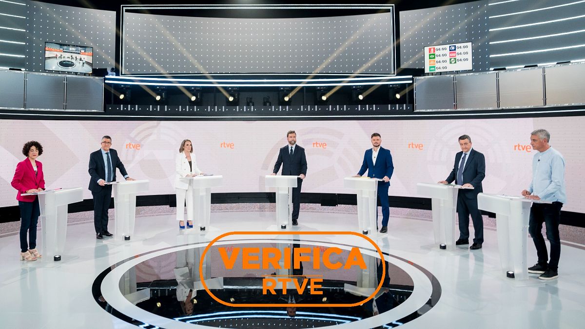 Debate a siete en RTVE. Fotografía de los/las portavoces de los partidos que se presentan a las elecciones generales, en el plató de RTVE. Con el sello VerificaRTVE en naranja.