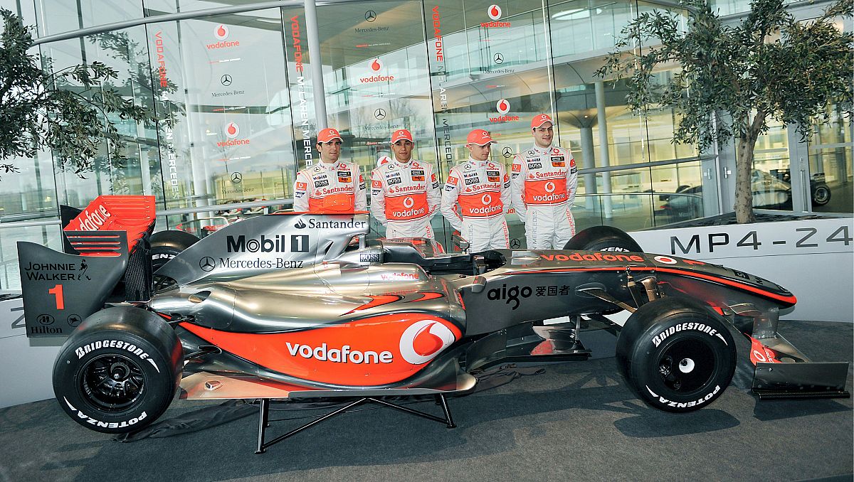 Lewis Hamilton (2º izq) y Heikki Kovalainen (2º dcha), posan junto a los pilotos probadores Pedro de la Rosa (izq) y Gary Paffet (dcha), tras el nuevo monoplaza.