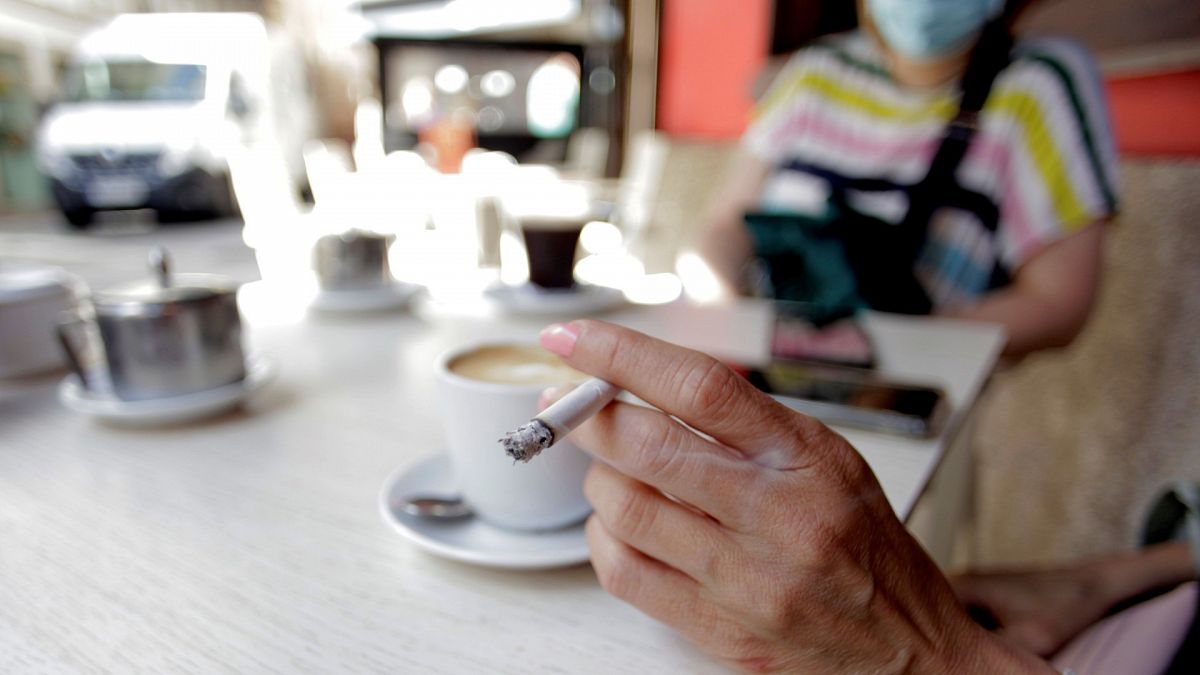 Una mujer fuma en la terraza de un bar