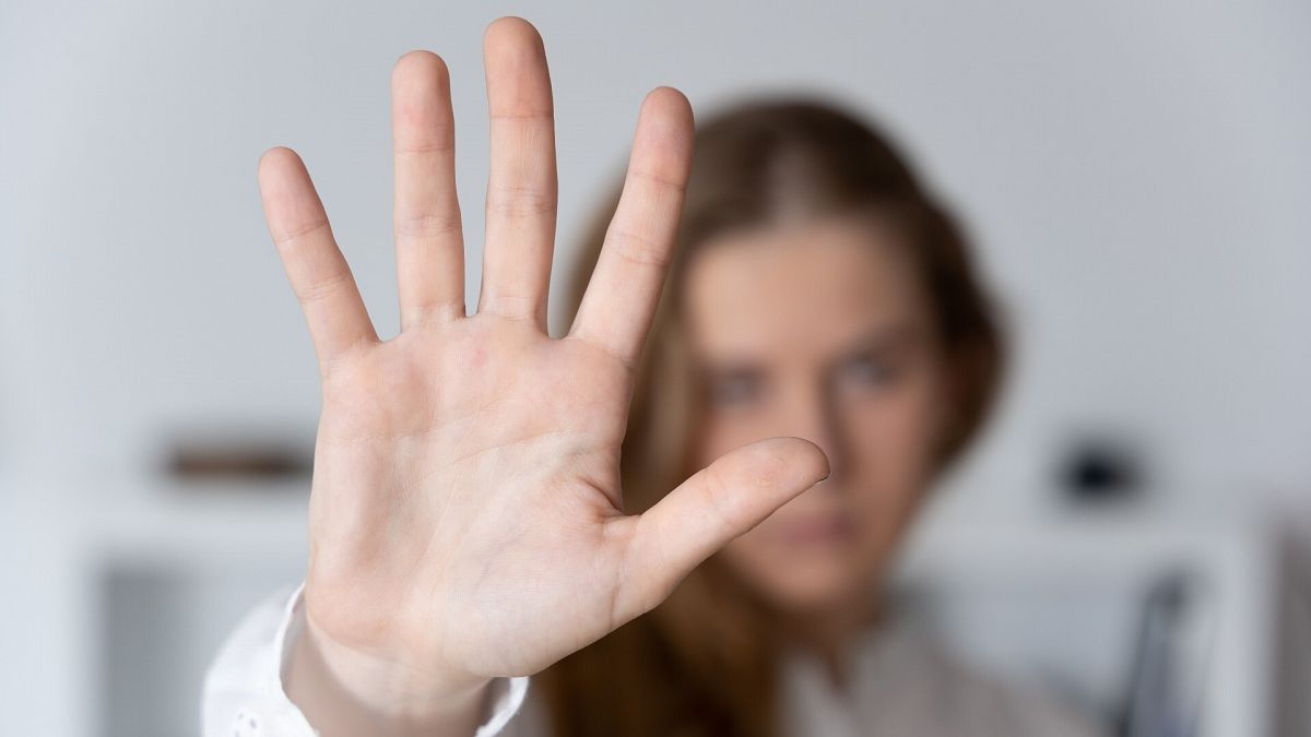 Una mujer levanta la mano en un gesto contra las agresiones sexuales