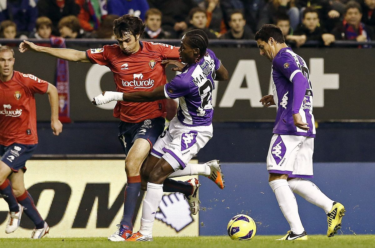 Los jugadores del Real Valladolid Mateus Contreiras "Manucho" (c) y Oscar González (d) pelean un balón con el defensa de Osasuna Alejandro Arribas
