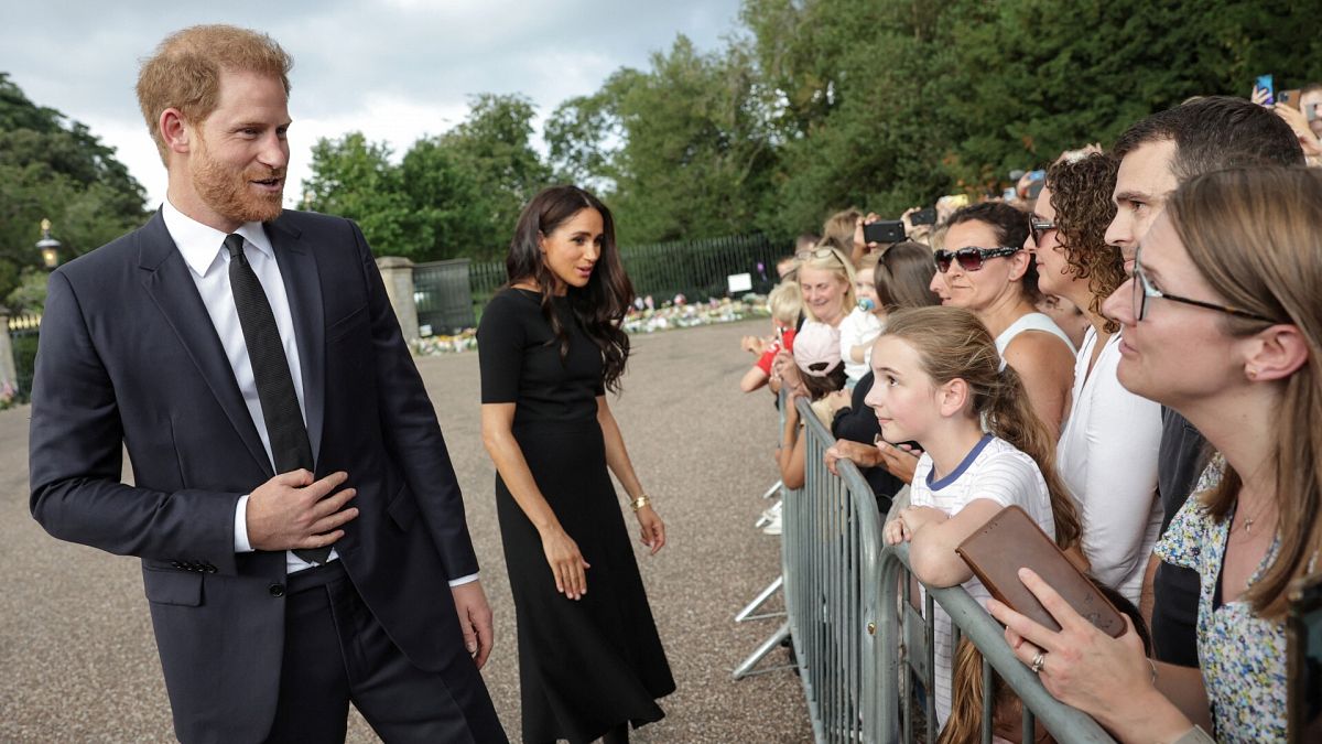 El príncipe Enrique y su mujer saludan a la multitud