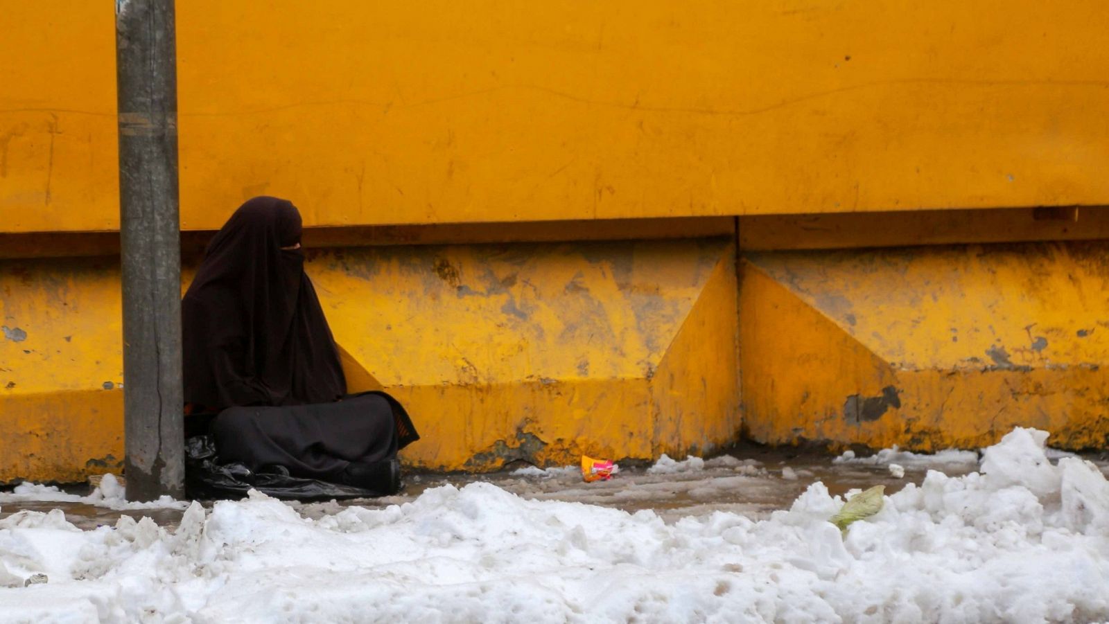 Una mujer afgana pide limosna durante una nevada en Kabul