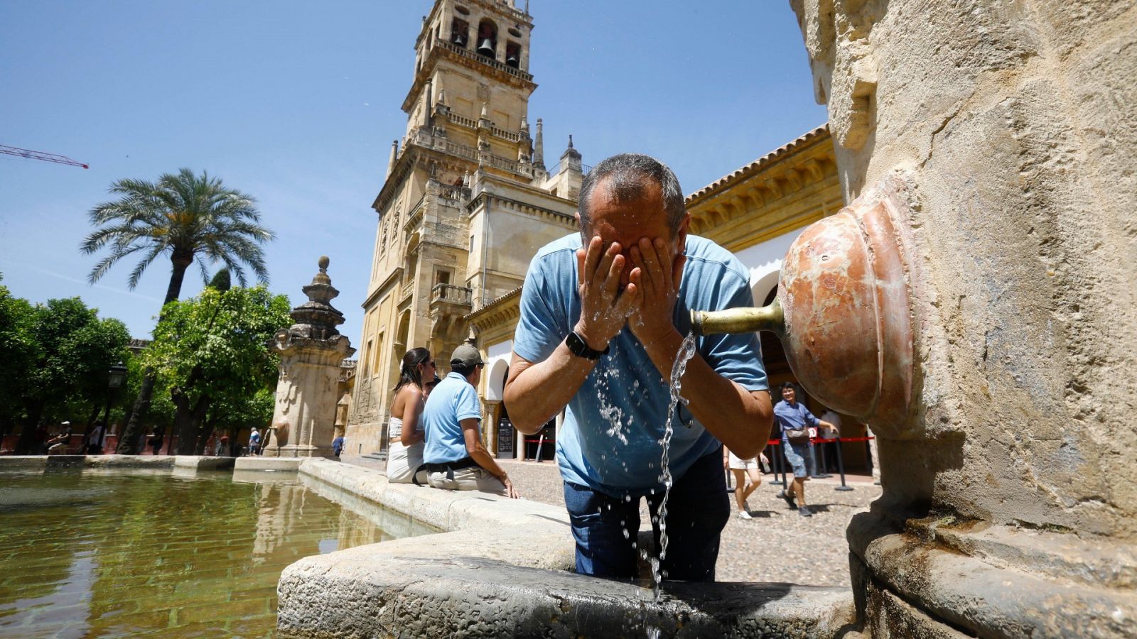 Un hombre se refresca en una de las fuentes del patio de los Naranjos en Córdoba