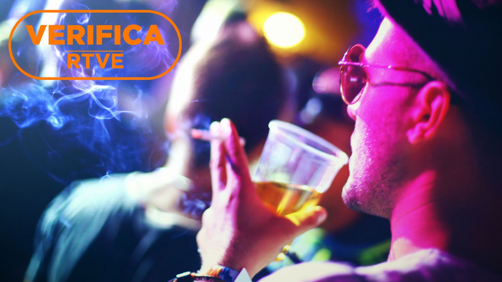Imagen de archivo de una persona consumiendo alcohol y fumando en una fiesta, con el sello VerificaRTVE en naranja