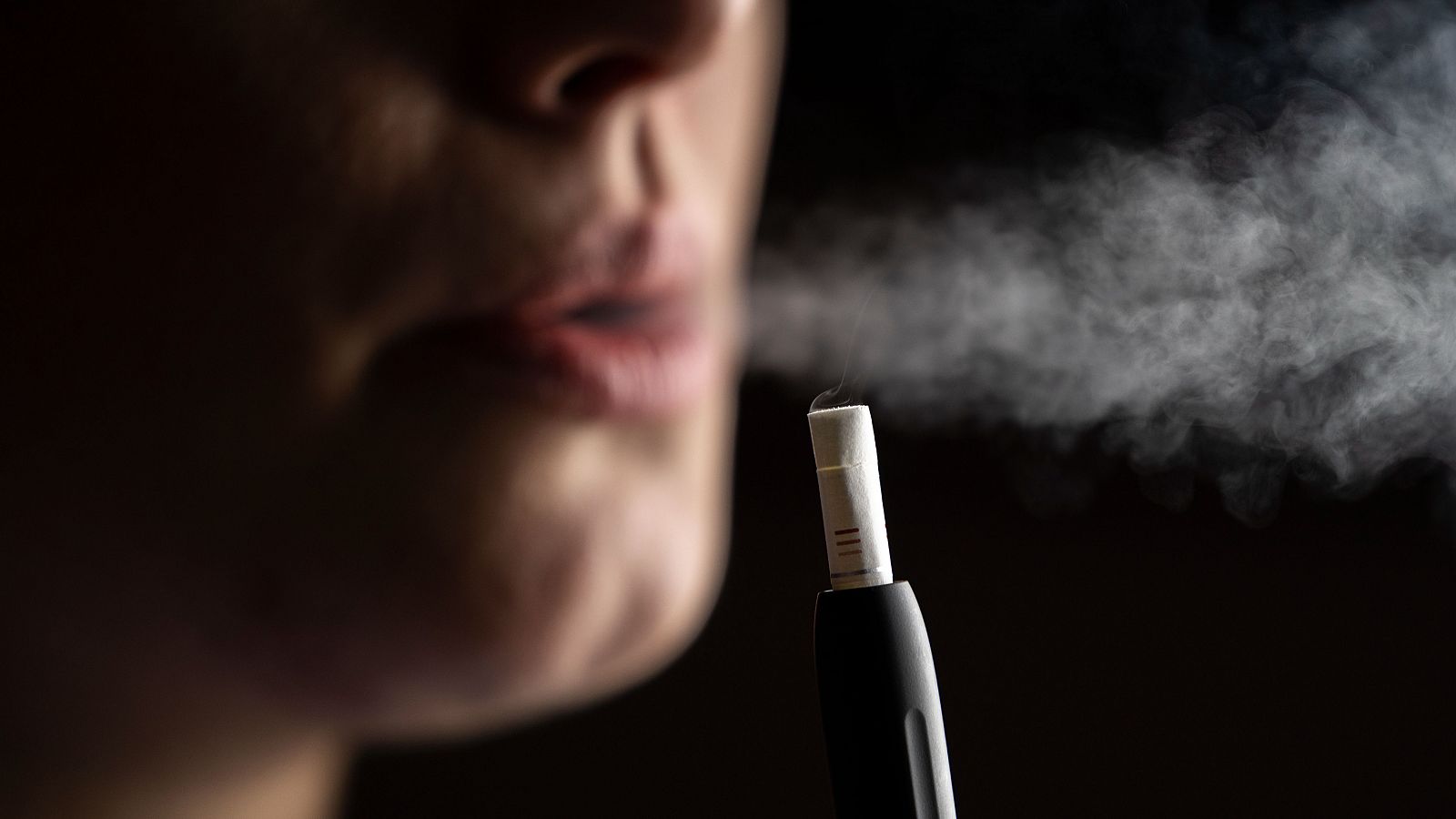 Tabaco calentado: una mujer utilizando un dispositivo electrónico para calentar tabaco