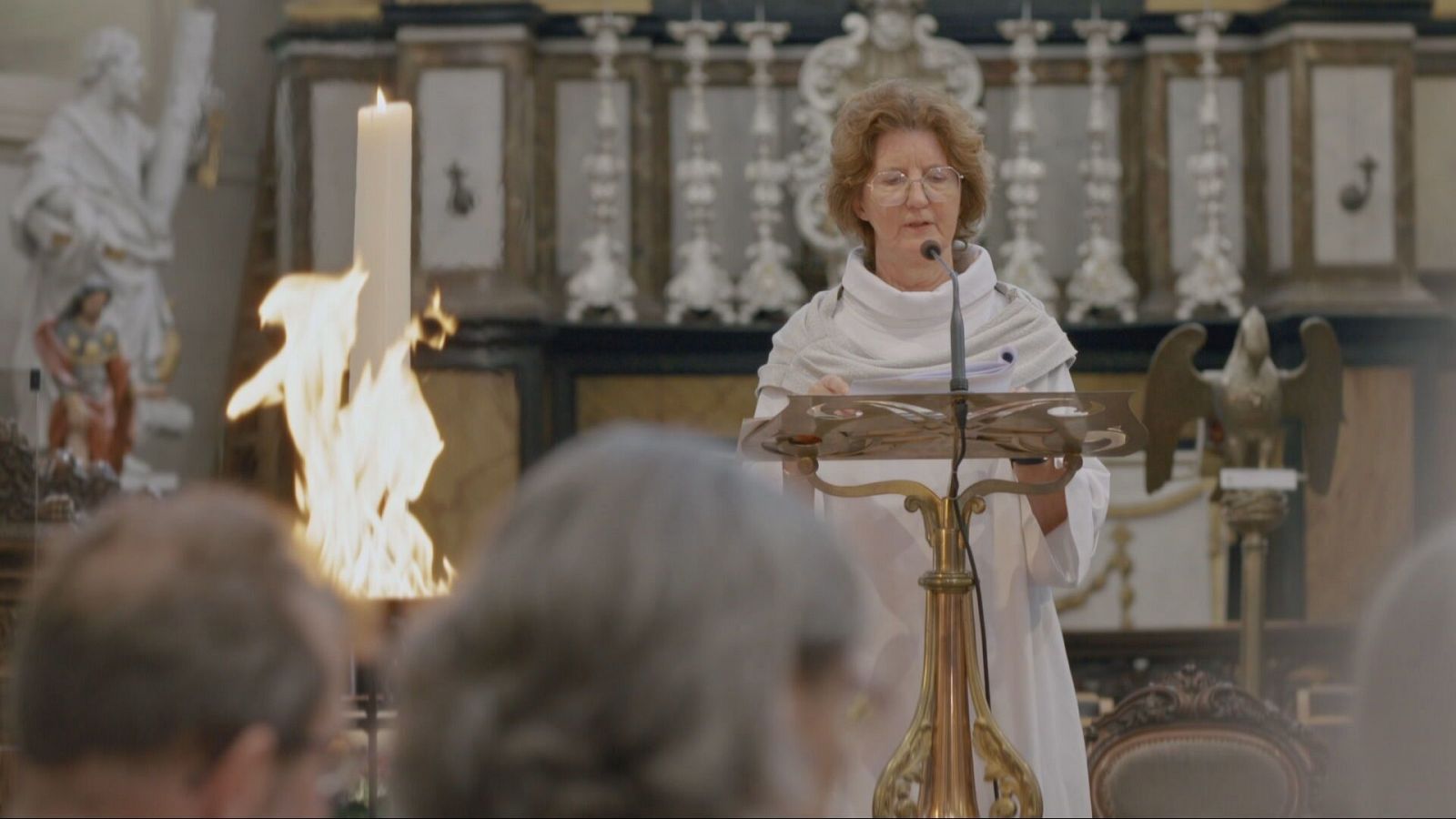 Una mujer predica desde un altar.