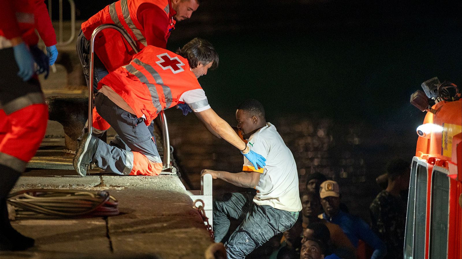 Operarios de Salvamento Marítimo ayudan a desembarcar en el puerto de Arrecife a uno de los 56 migrantes de origen subsahariano rescatados en la noche del jueves 8 de febrero.