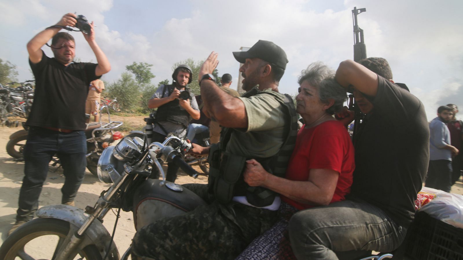 Palestinos transportan en moto a una civil capturada en el kibutz Kfar Azza.