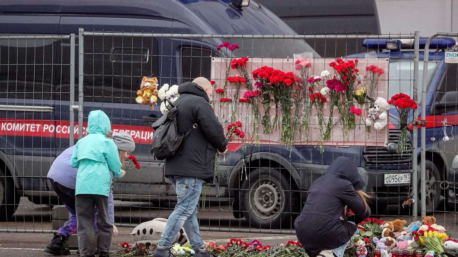 Varias personas llevan flores a Crocus City Hall incendiada tras un atentado terrorista en Krasnogorsk, a las afueras de Moscú