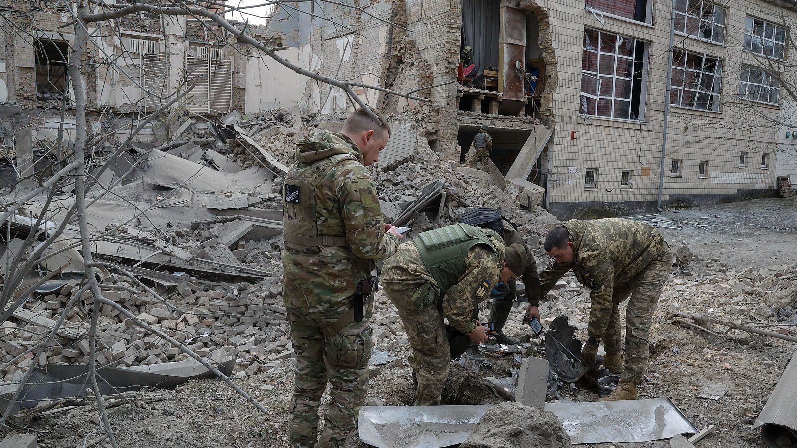Soldados ucranianos trabajan en el sitio de un edificio dañado después de un ataque ruso con misiles en Kiev