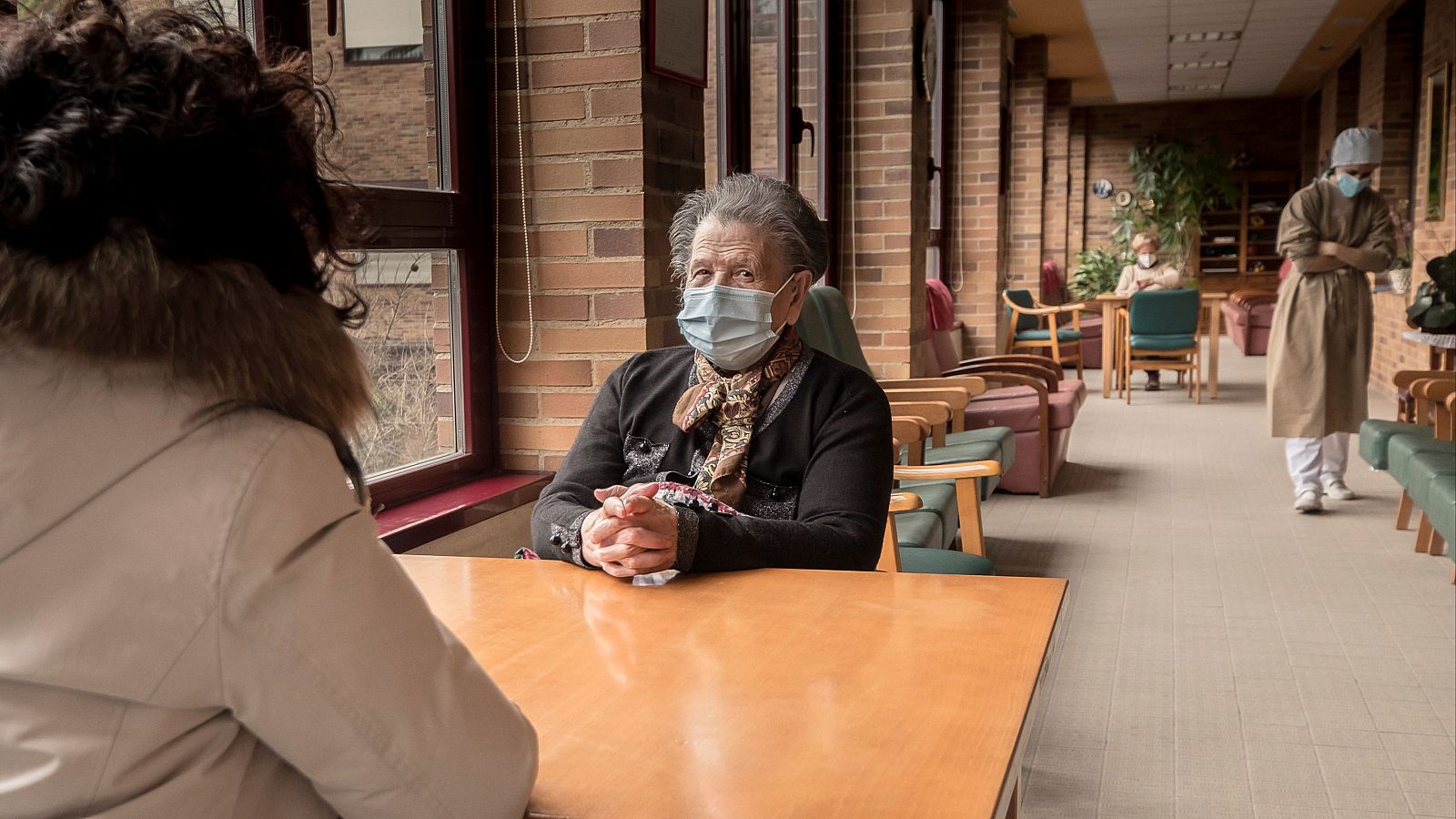 Una usuaria de una residencia recibe una visita durante la pandemia de coronavirus en el año 2021