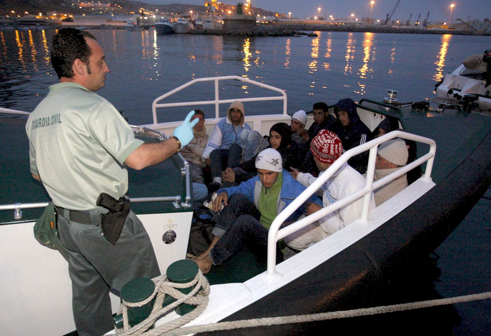 Los once inmigrantes, todos varones, que navegaban en una patera llegan al puerto de Almería después de que la Guardia Civil les intercepatara a 20 millas al sur del Cabo de Gata.