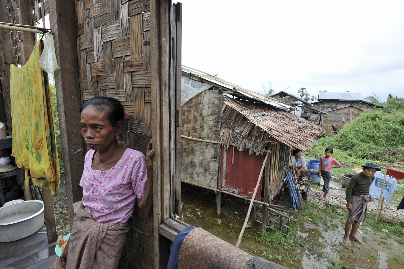 Un grupo de habitantes de una aldea cercana a Pyapon, Birmania, observa los daños qeu el Nargis ha causado en sus casas.