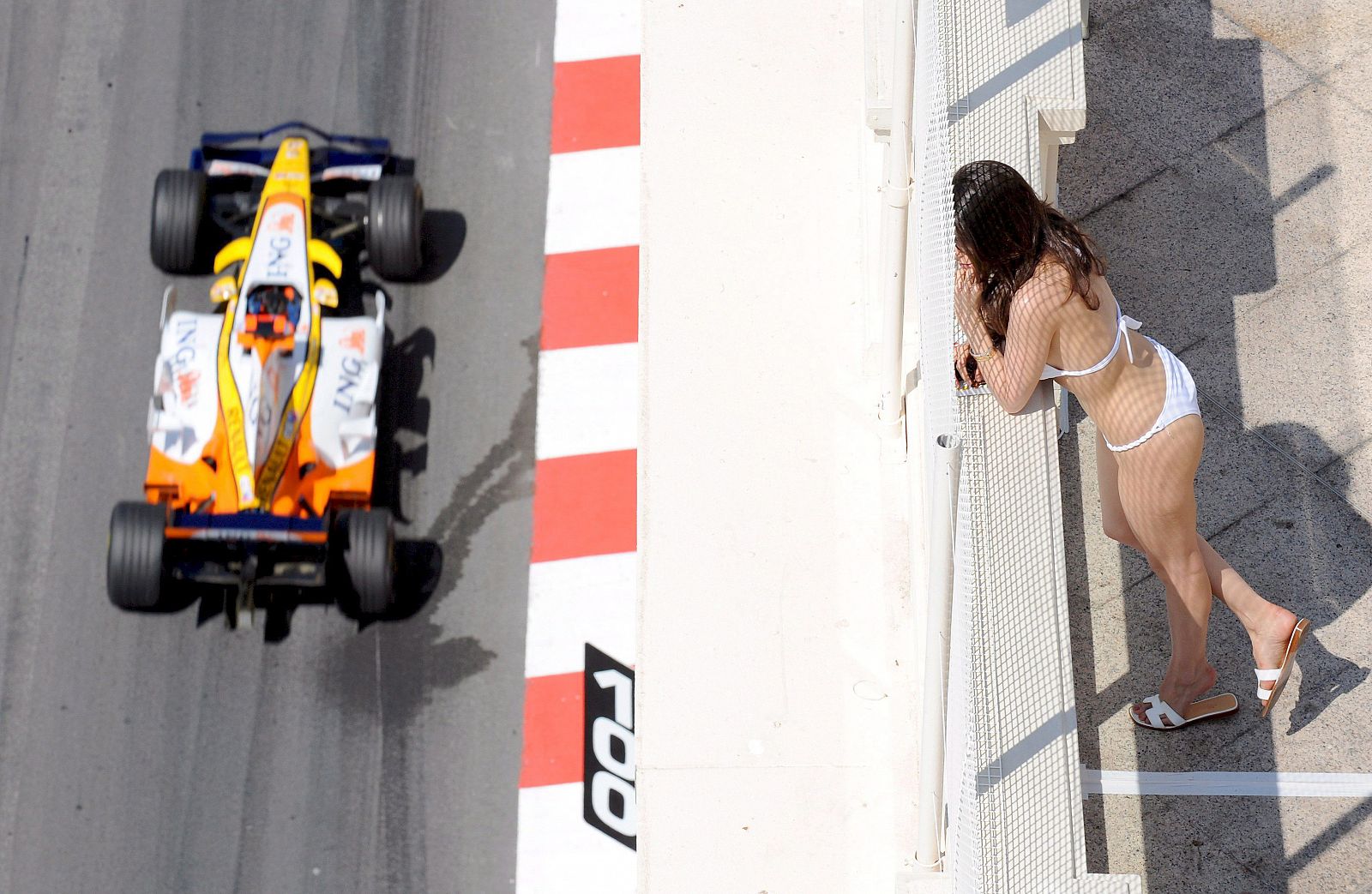 Una mujer en traje de baño observa al piloto español durante la primera sesión libre en Montecarlo.