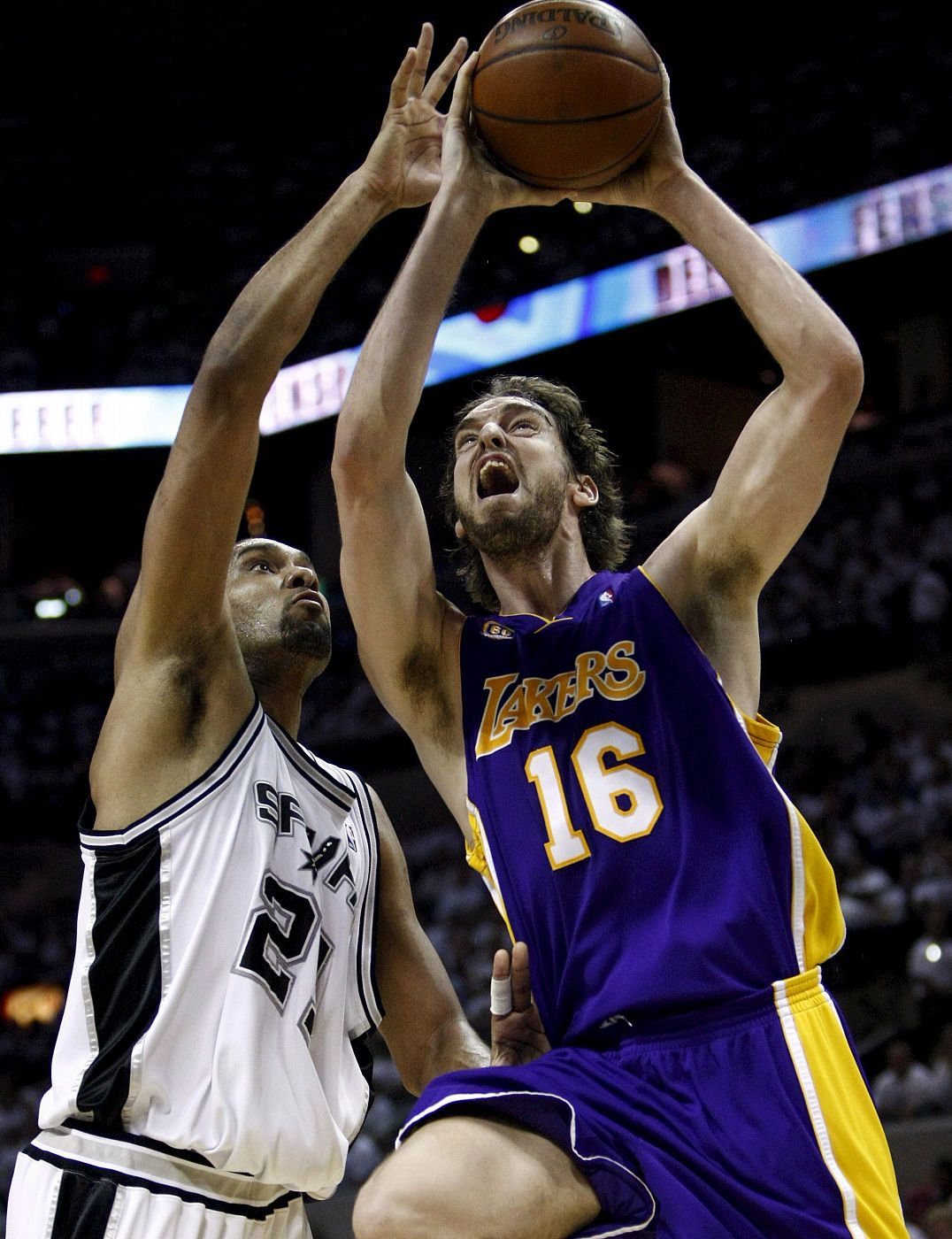 El español Pau Gassol de los Lakers de los Ángeles va hacia la cesta con la marca de Tim Duncan