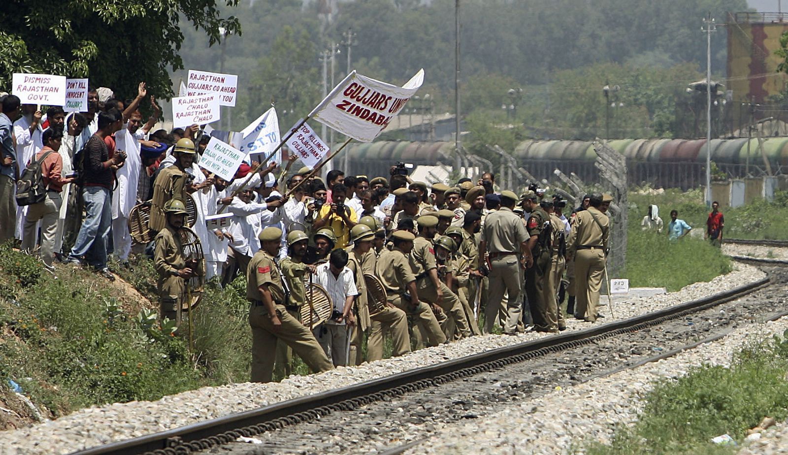 Indian police stop members of Gujjar community as they try to block a railway track in Jammu