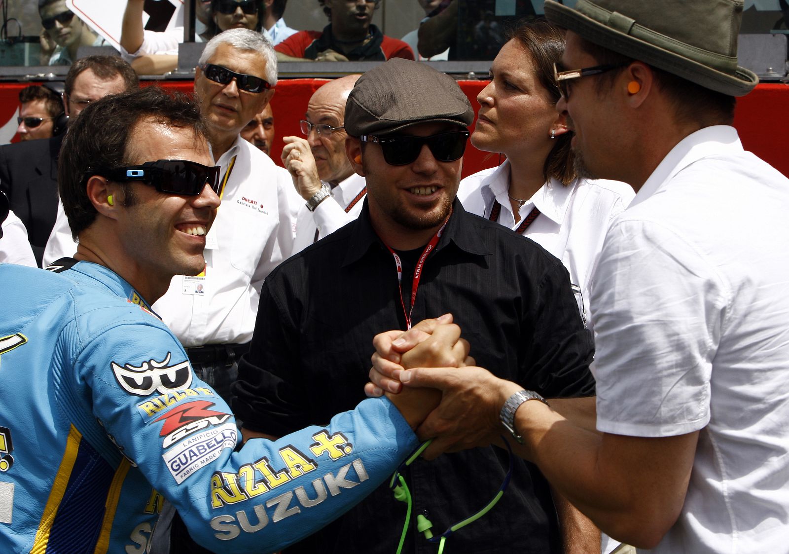 Brad Pitt saluda al piloto italiano Loris Capirossi después de la carrera.