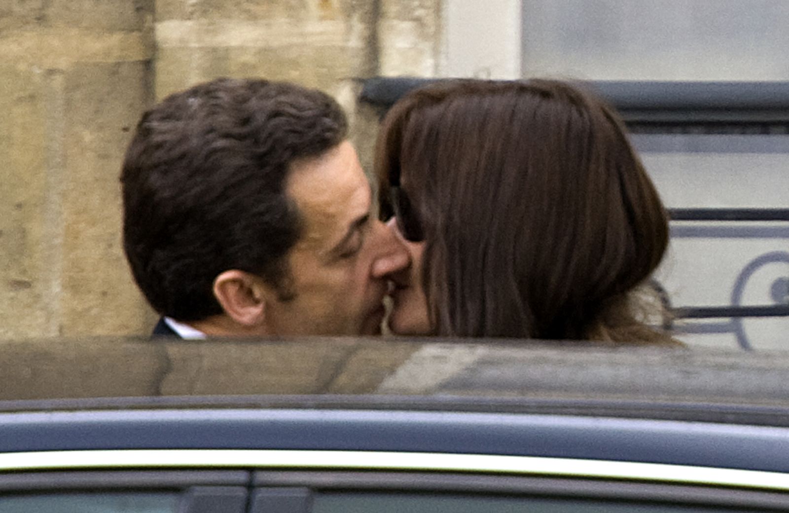 France's President Nicolas Sarkozy kisses first lady Carla Bruni-Sarkozy as they leave the Elysee Palace in Paris