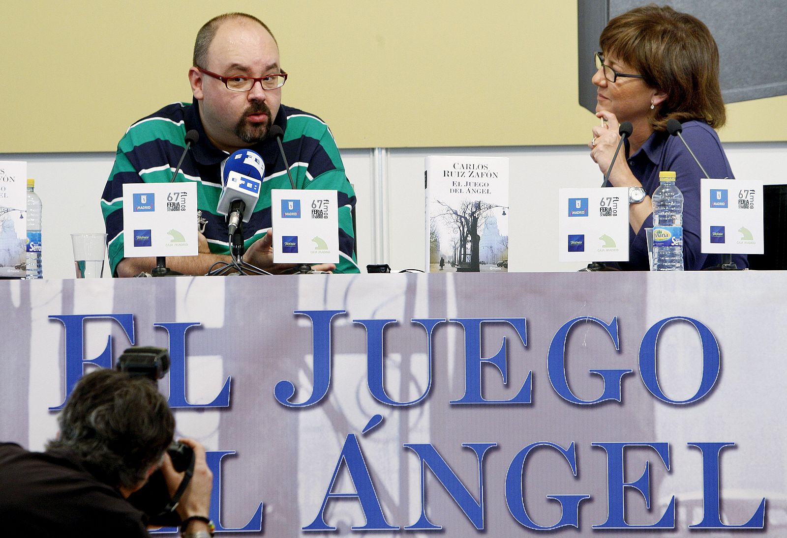 El escritor Carlos Ruiz Zafón, acompañado de la periodista Olga Viza, durante la presentación en la Feria del Libro de Madrid de su última novela, "El juego del ángel".