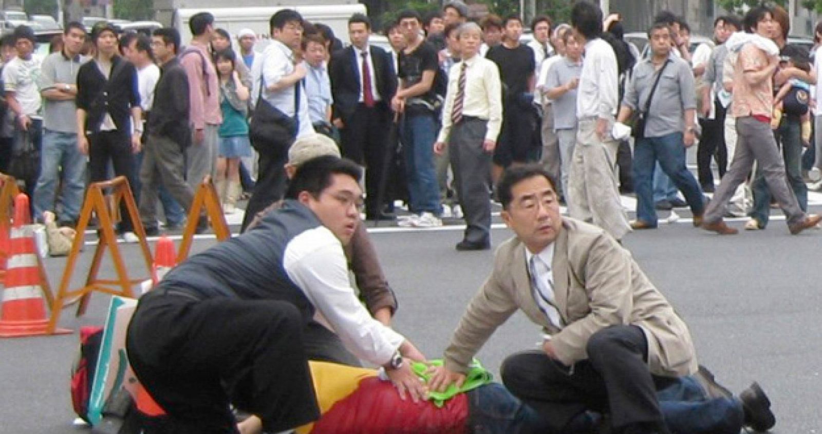 Un grupo de viandantes asisten a uno de los apuñalados en Tokio.