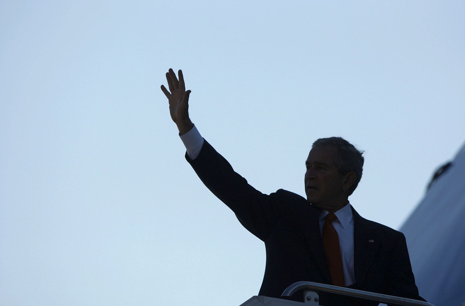 Bush saluda desde la escalerilla del Air Force One antes de partir hacia Europa, en su última visita como presidente