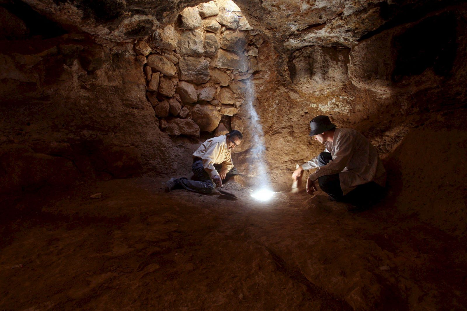 Dos arqueólogos jordanos trabajan en una cueva situada bajo una antigua iglesia de la ciudad jordana de Rehab.