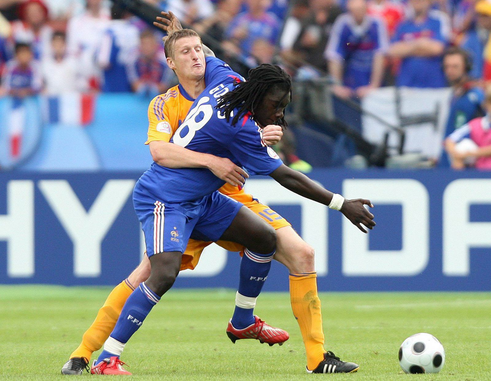 El jugador francés Bafetimbi Gomis lucha por el balón con el rumano Dorin Goian, en un encuentro muy enmarañado.