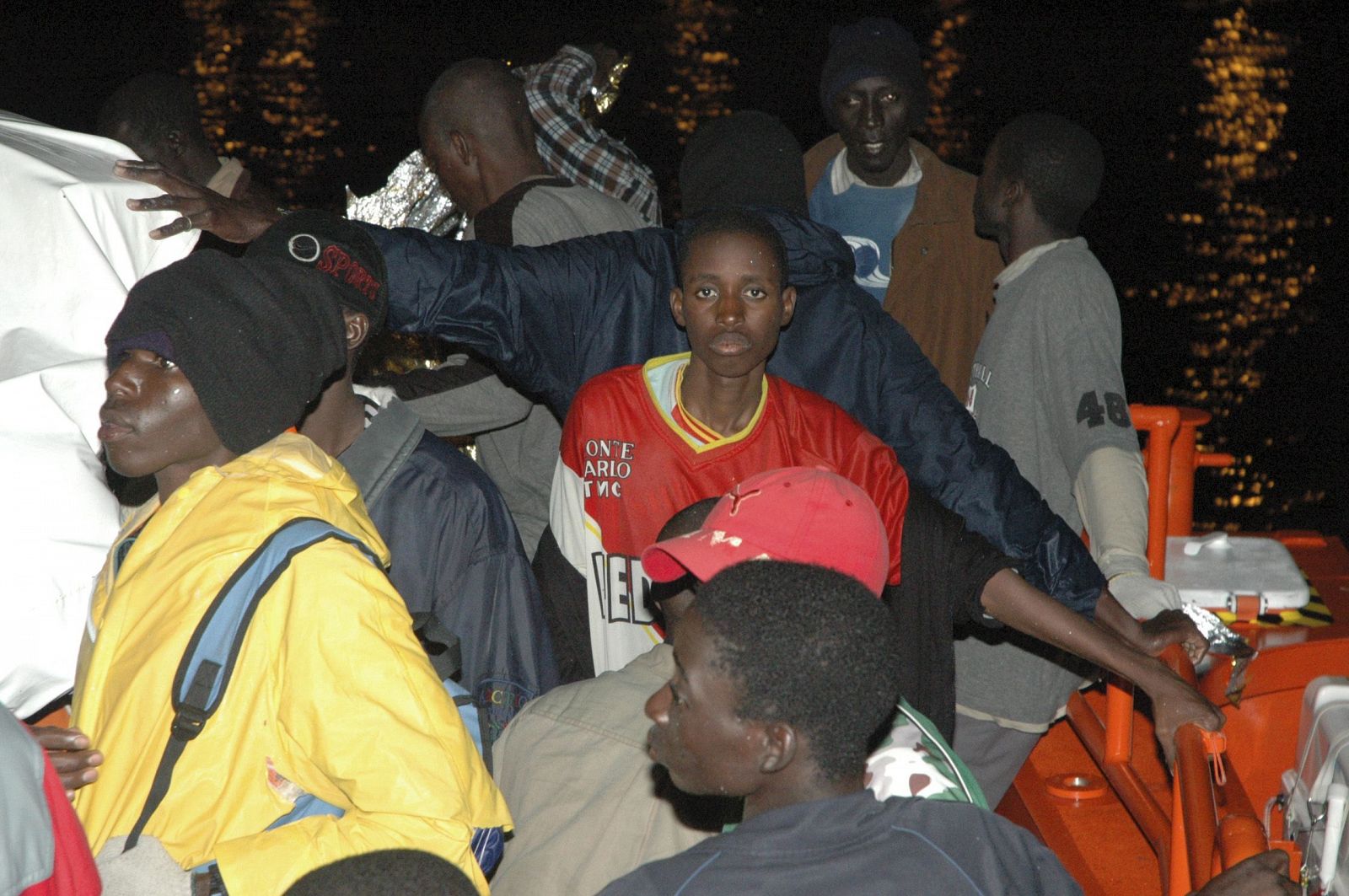 Parte de los inmigrantes que viajaban en los dos cayucos avistados a más de 85 millas al sur de Gran Canaria esperan para ser desembarcados esta noche en el puerto de Gran Canaria.