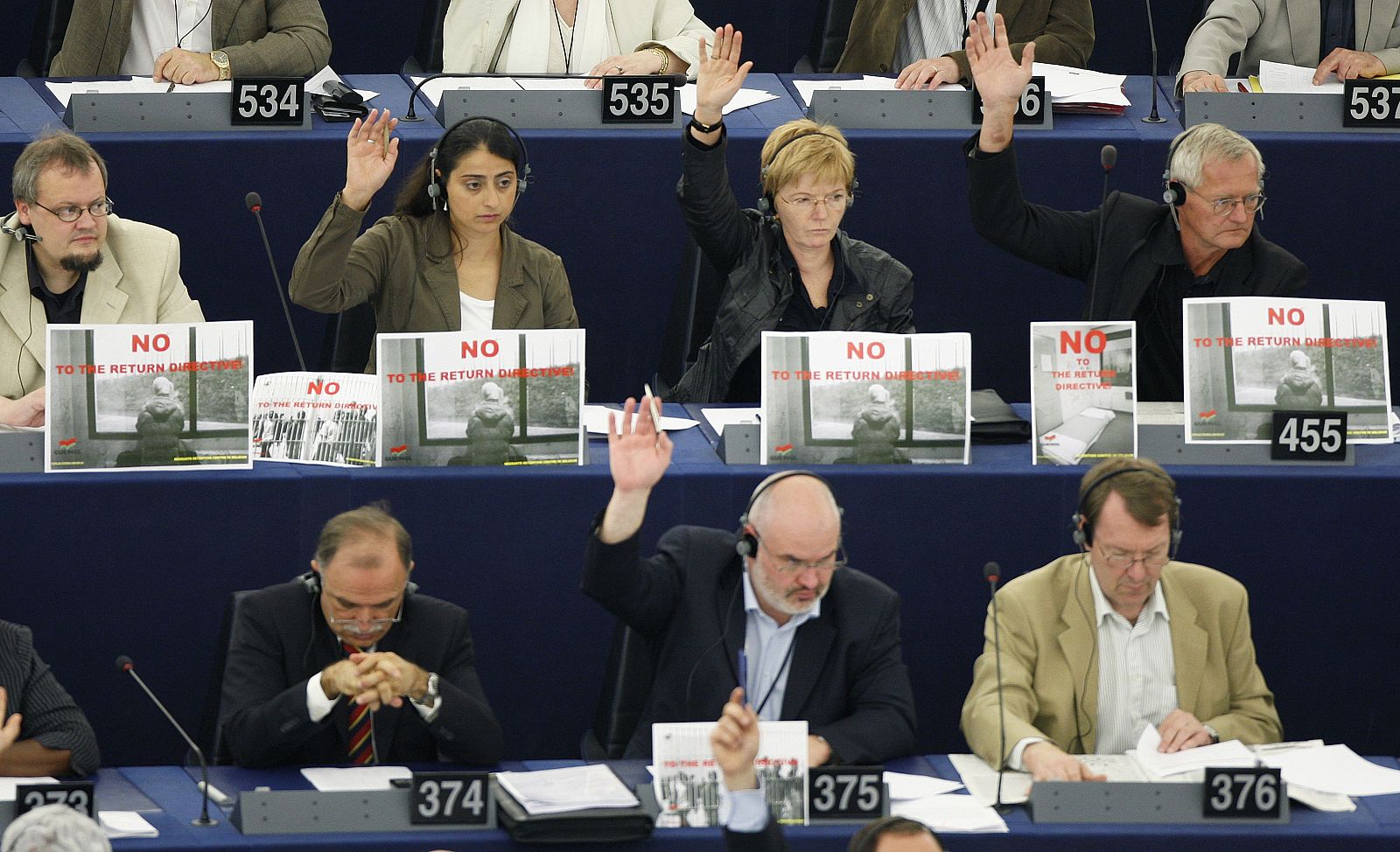 Eurodiputados de la Izquierda Unitaria Europea llevan carteles contrarios a la directiva de retorno durante la votación en el Parlamento Europeo.