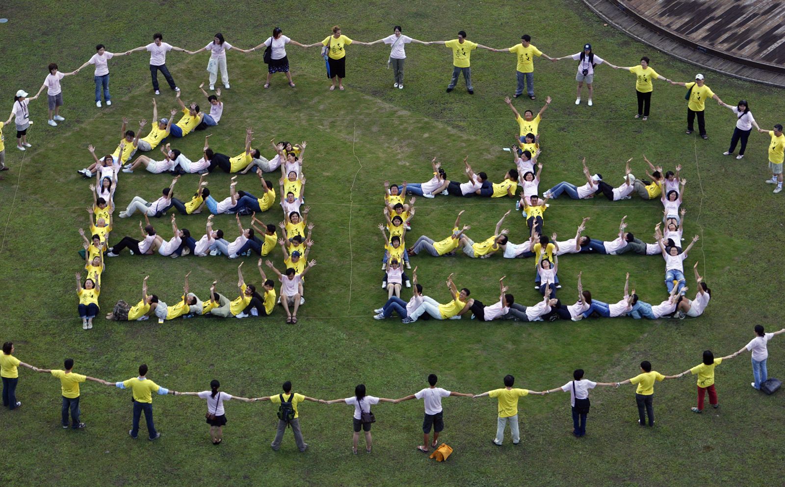 Manifestantes de Amnistía Internacional forman con las manos unidas la palabra "libertad" en chino.
