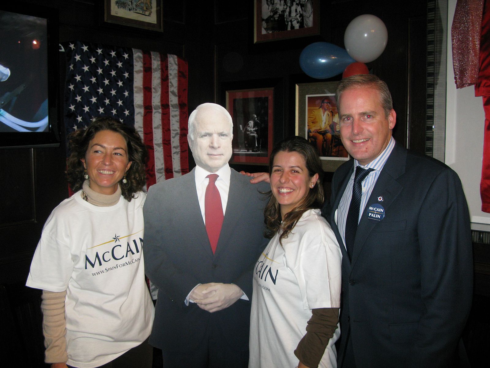 El Presidente de Spain for McCain, Edward Ruff, posa junto a la figura del candidato reublicano y unas seguidoras.