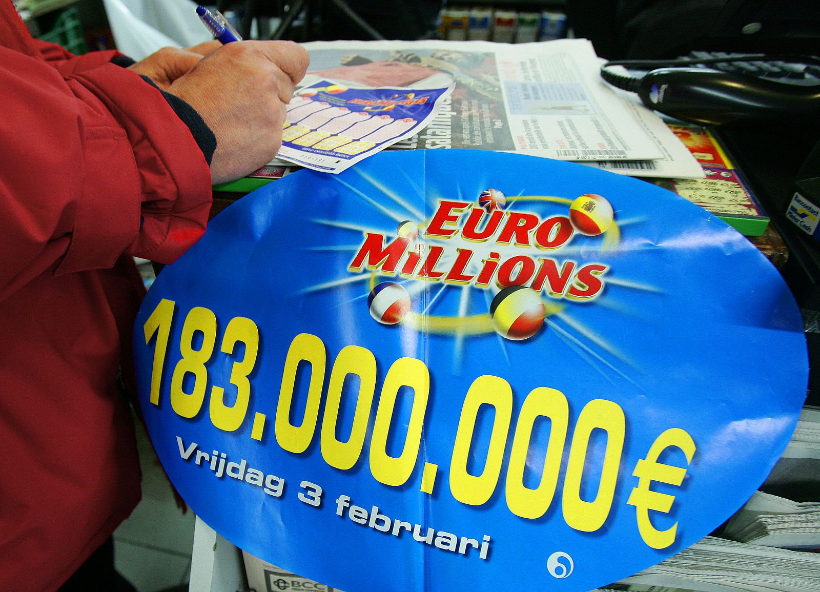 A customer selects numbers on a "EuroMillions" lottery ticket in a shop in Brussels