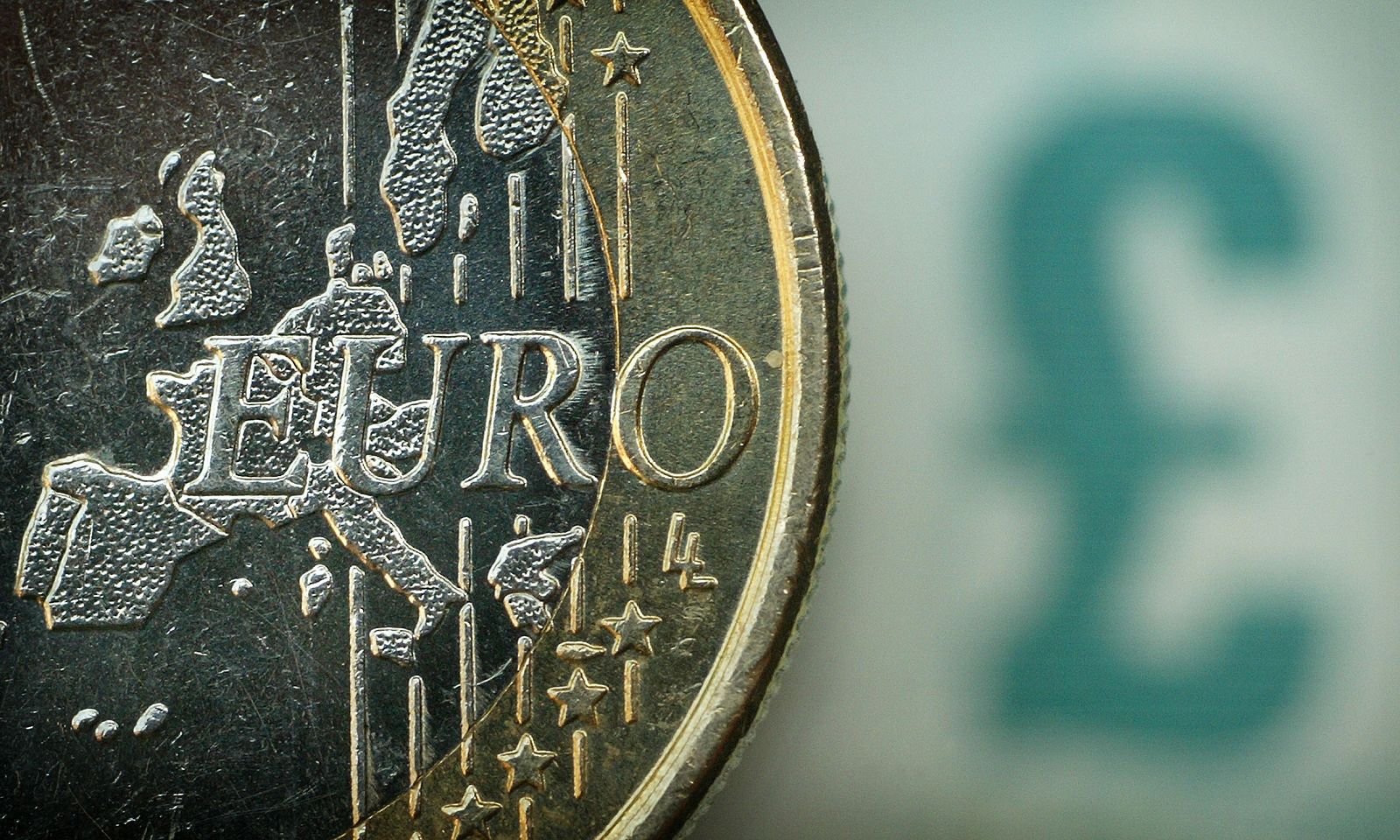 Imagen de una moneda de euro sobre un billete de cinco libras.