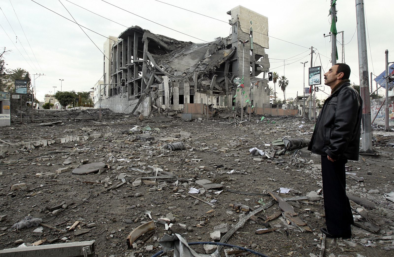 Un hombre mira la destrucción del Parlamento de Gaza tras un nuevo bombardeo israelí en las primeras horas del año.