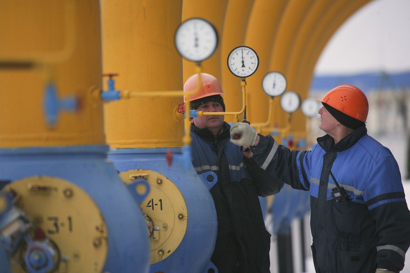 Workers check the pressure at the Nesvizhskaya gas compressor station near Minsk