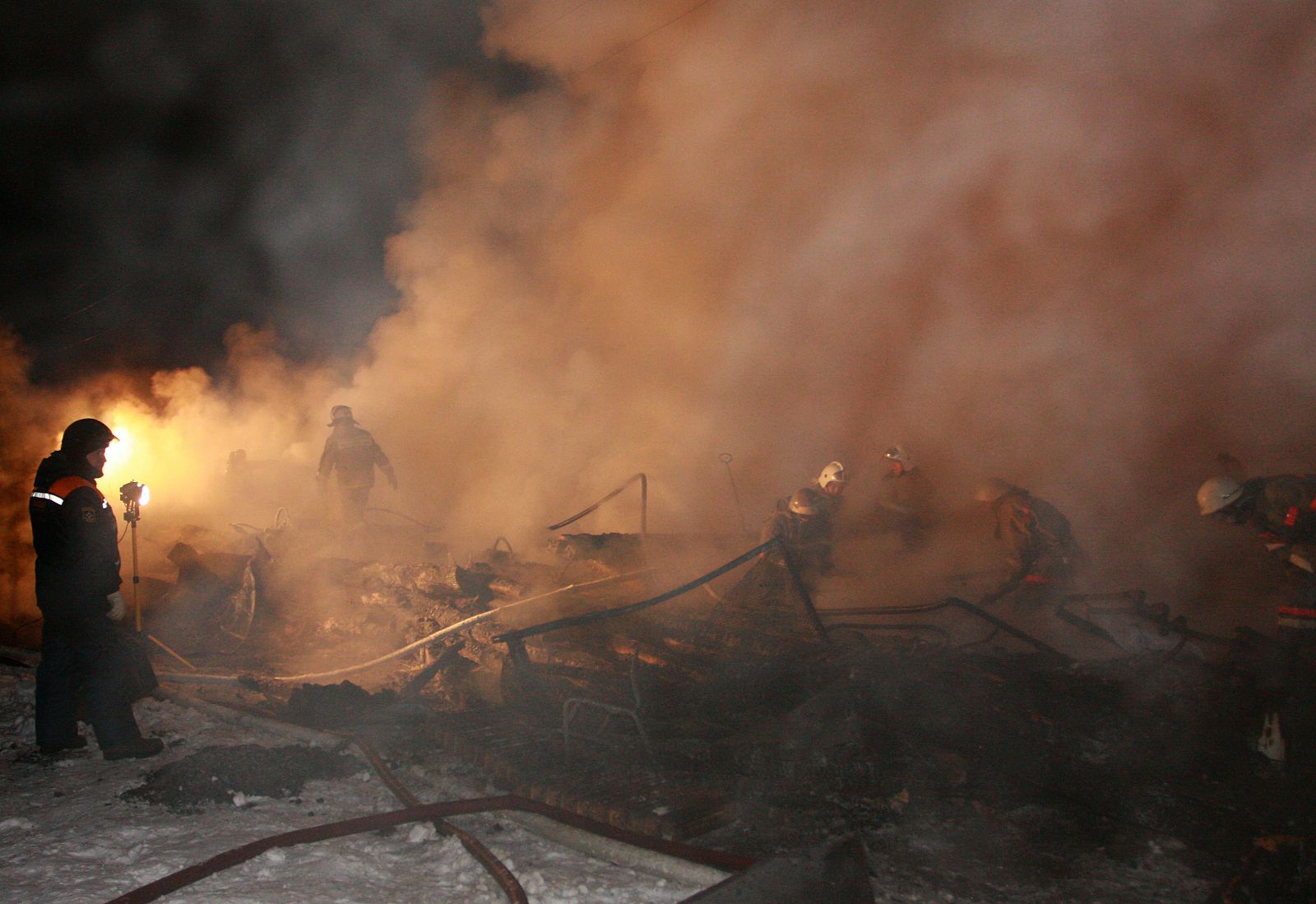 Firefighters search through the rubble of an old people's home in the village of Podyelsk