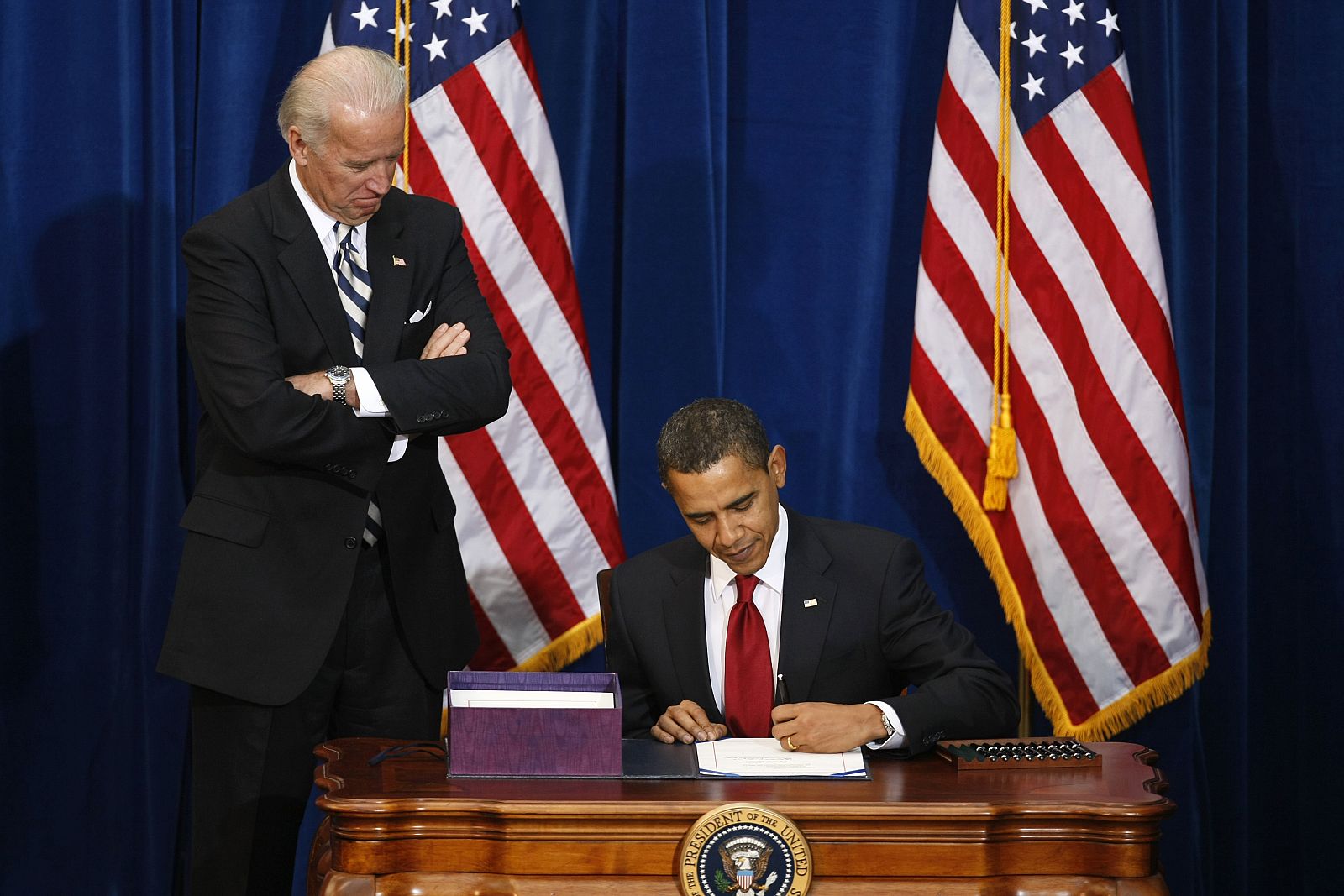 El presidente estadounidense, Barack Obama, firma el plan de estímulo en Denver, bajo la mirada del vicepresidente Joe Biden.