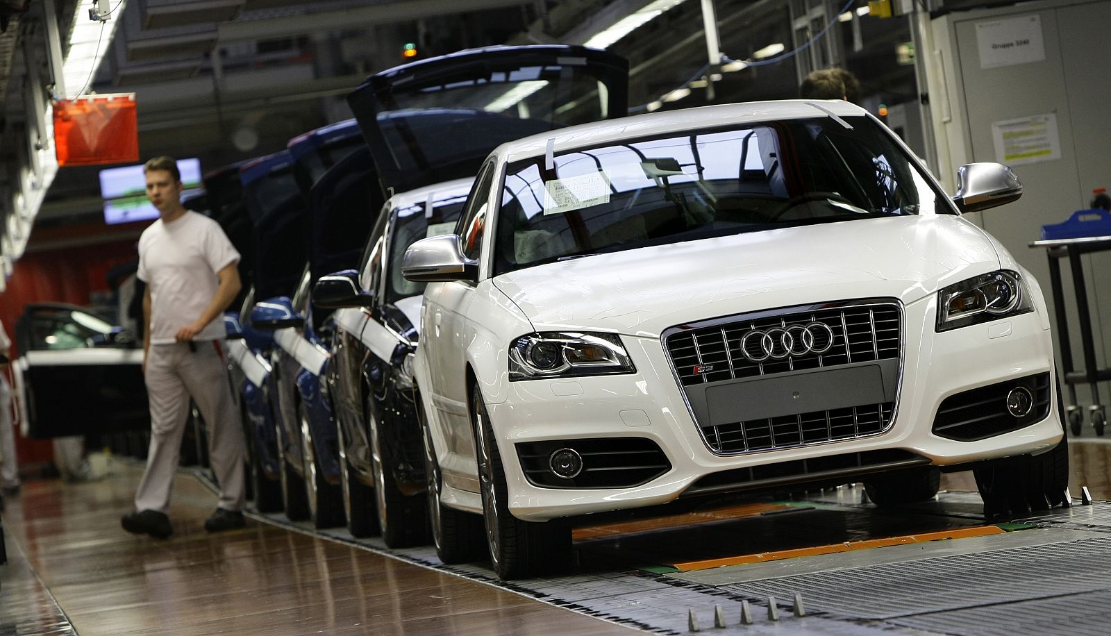 An employee walks next to the A3 production line in the German car manufacturer Audi in Ingolstadt