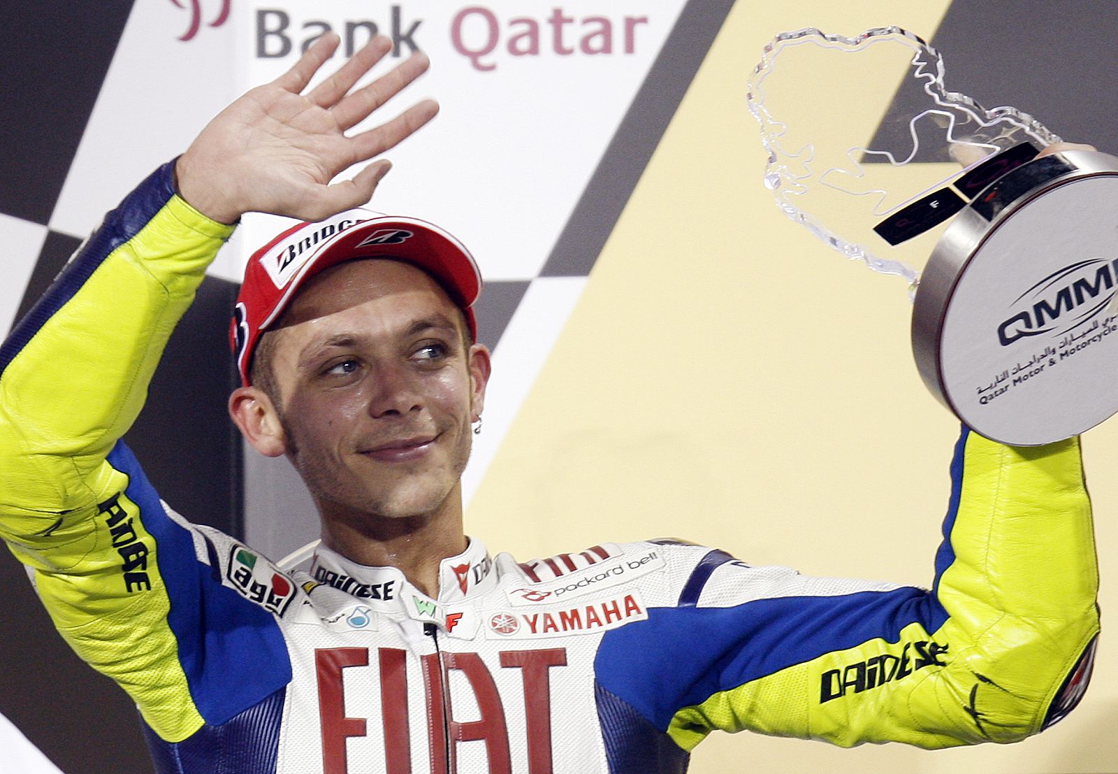 El piloto de Yamaha Valentino Rossi alza su trofeo después de quedar en segunda posición en el GP de Qatar.