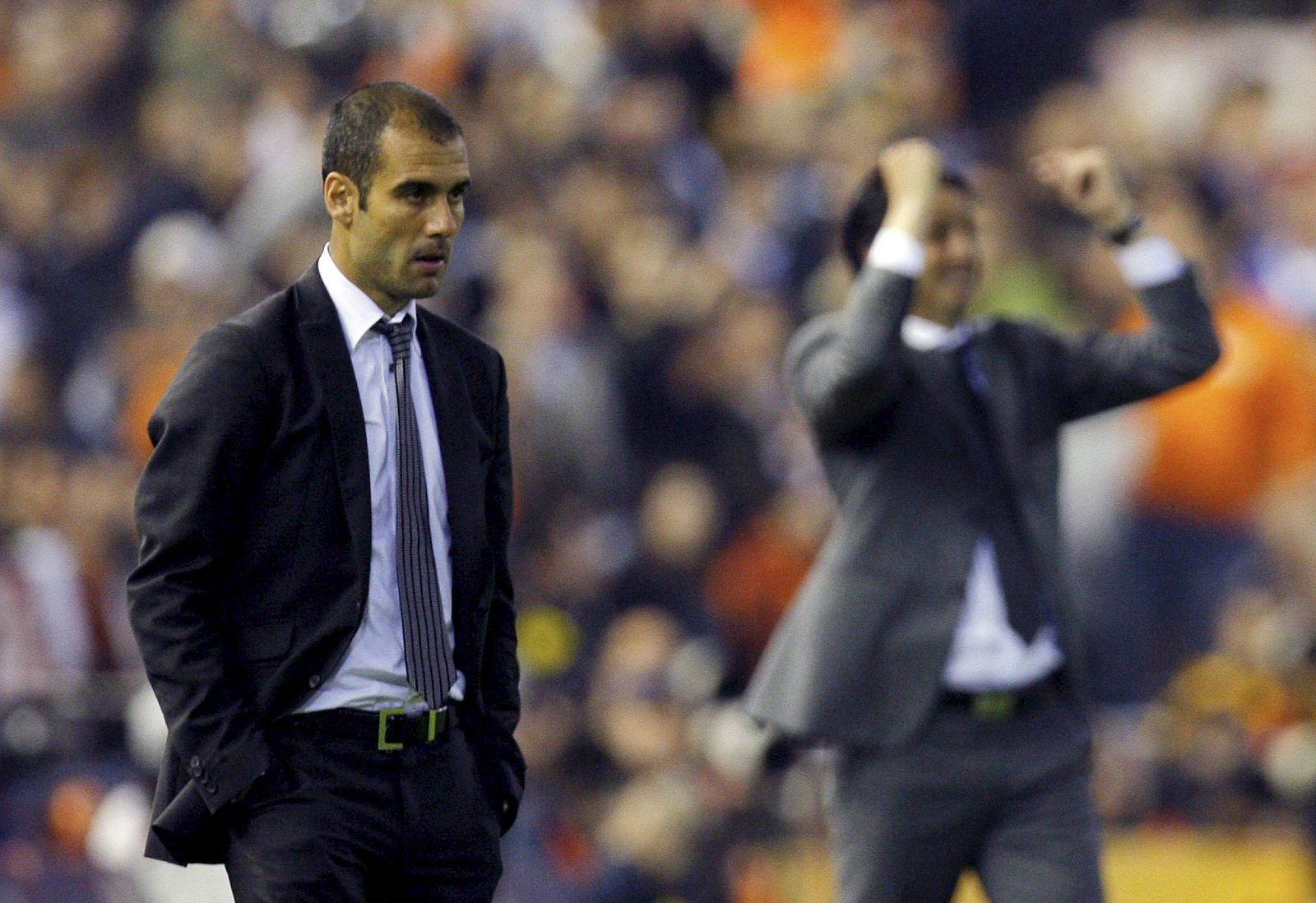 Guardiola observa el partido mientras Emery celebra un gol del Valencia.