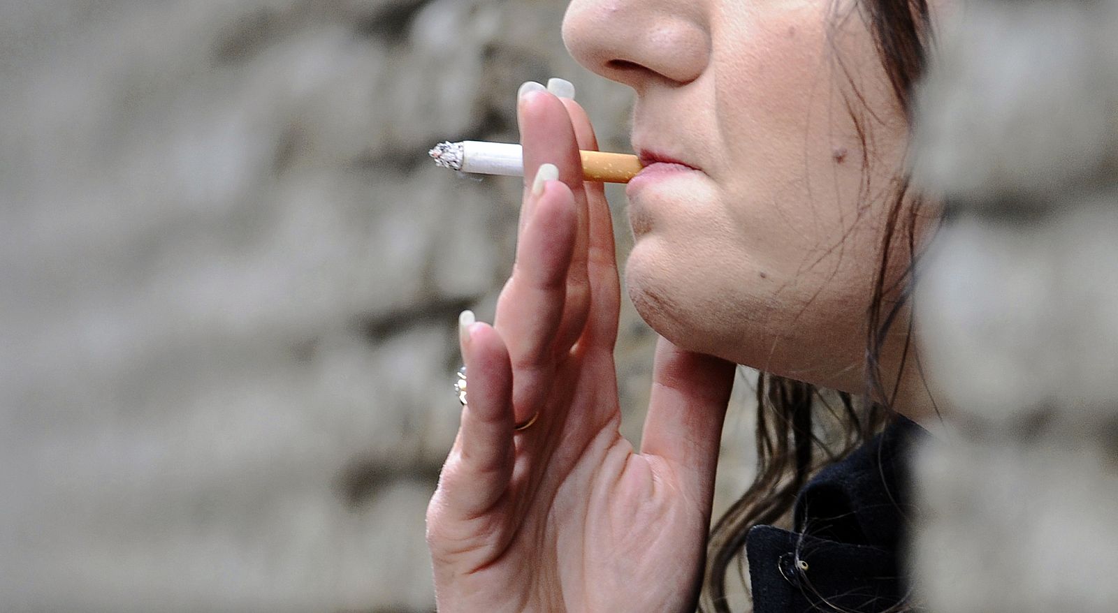 Una mujer fuma un cigarrillo