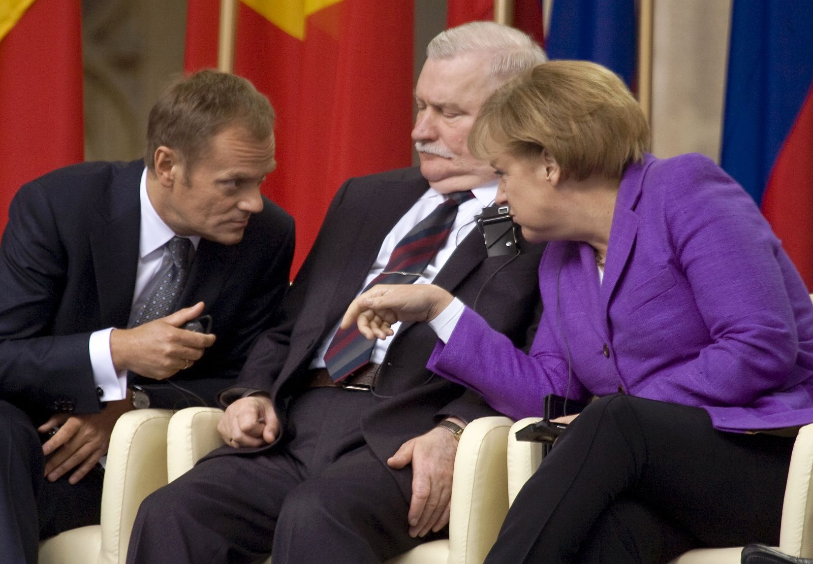 El primer ministro polaco, Donald Tusk, charla con la canciller alemana, Angela Merkel, mientras el ex presidente y sindicalista Lech Walesa escucha entre ambos.