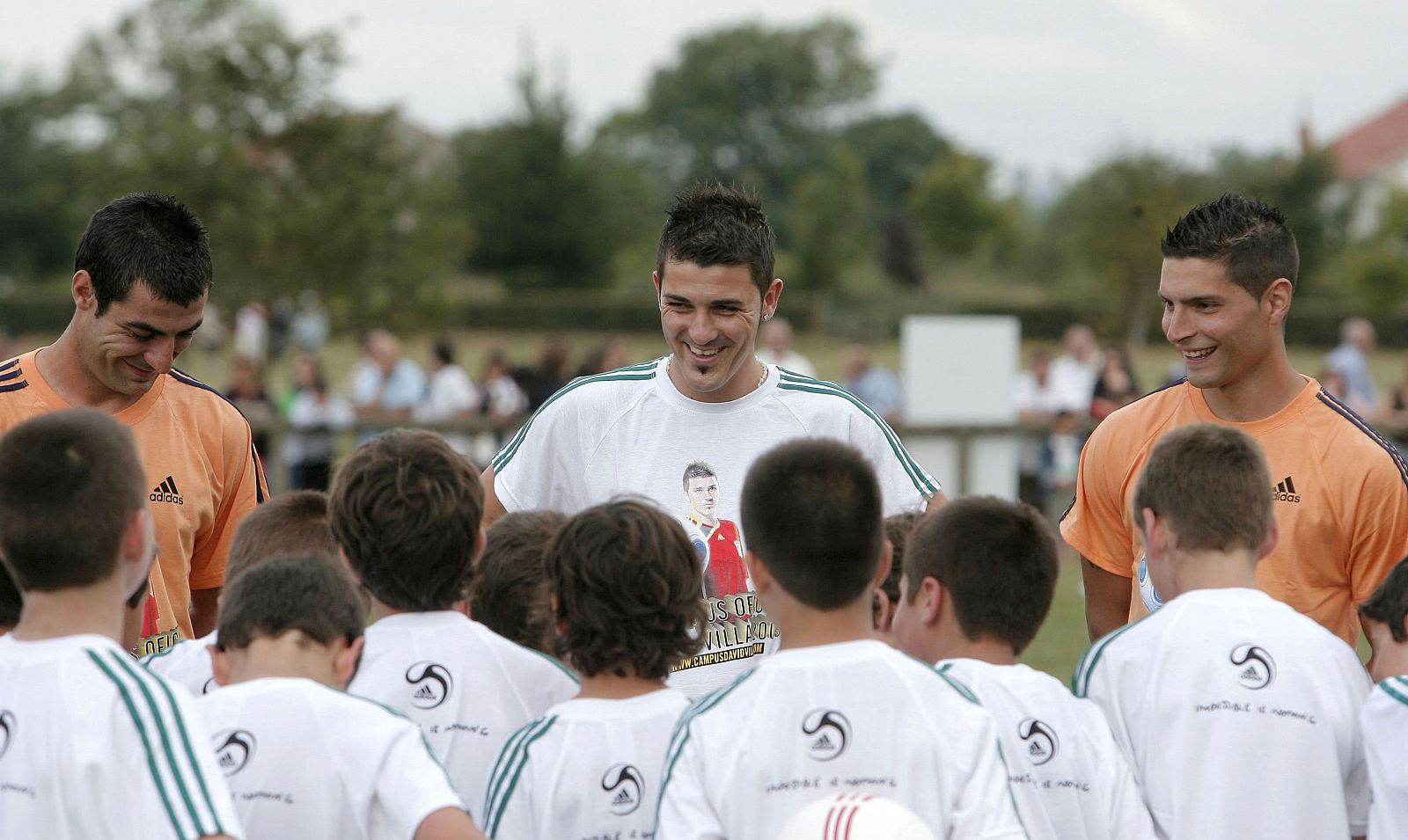 El futbolista sonríe a un grupo de niños de su campus oficial.