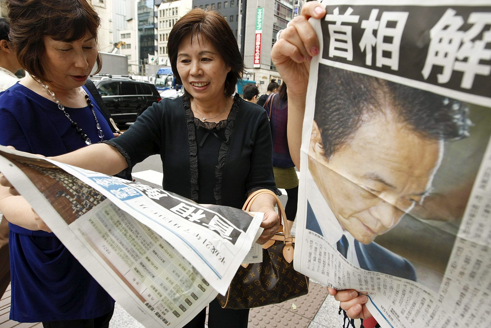 Varias mujeres consultan la prensa tras el anuncio de elecciones generales del primer ministro japonés.