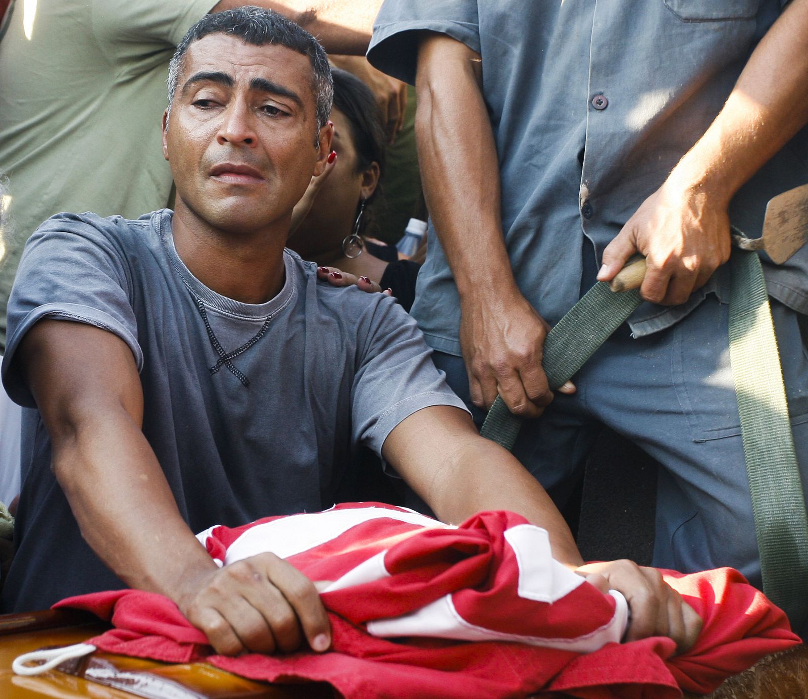 Romario llora ante el féretro de su padre, cubierto con una bandera del América de Río.