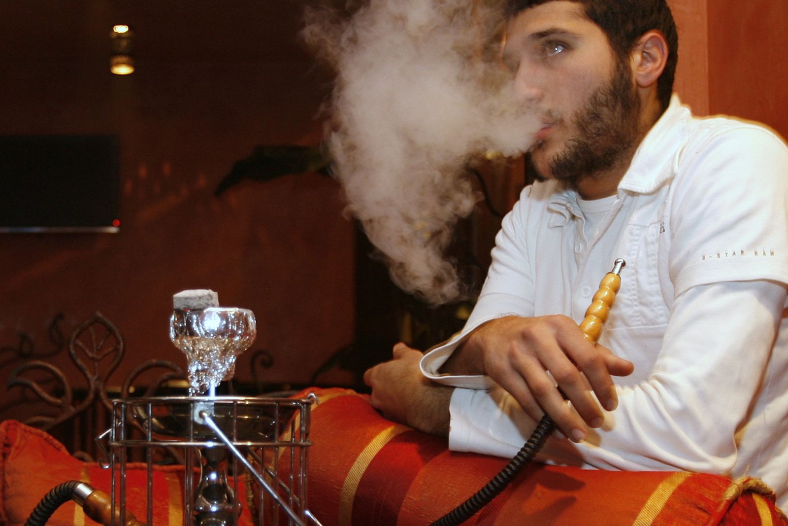 Un hombre fuma 'shisha' en un bar de París.