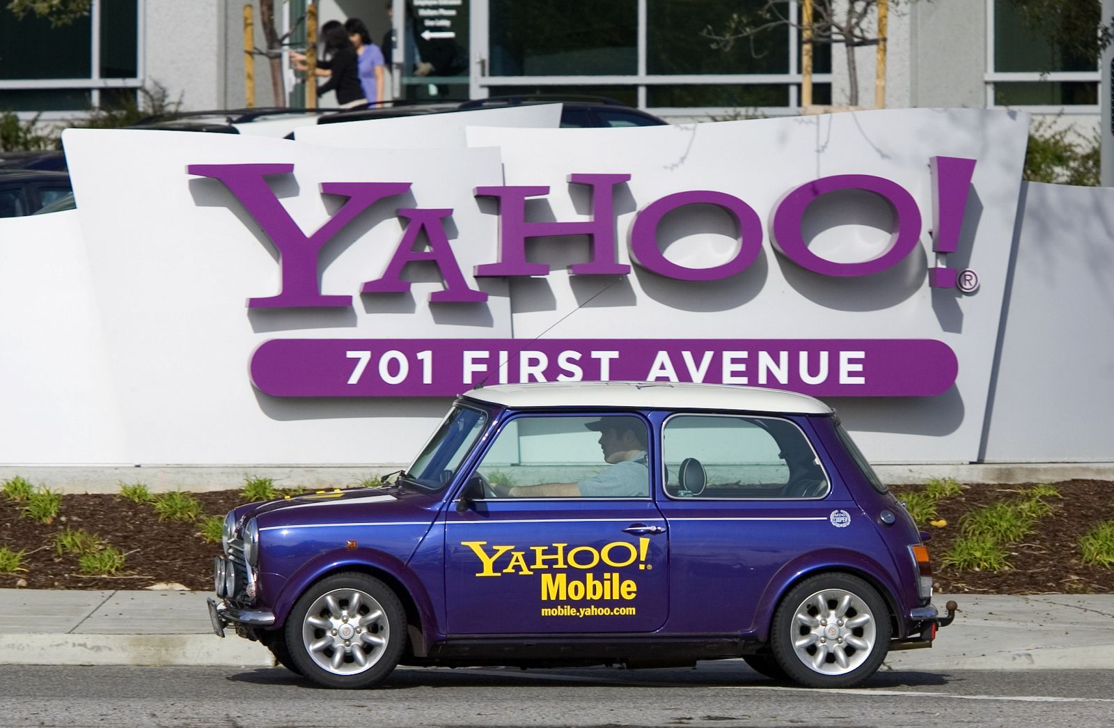 A man drives a Mini Cooper with a Yahoo! logo in front of Yahoo! headquarters in Sunnyval