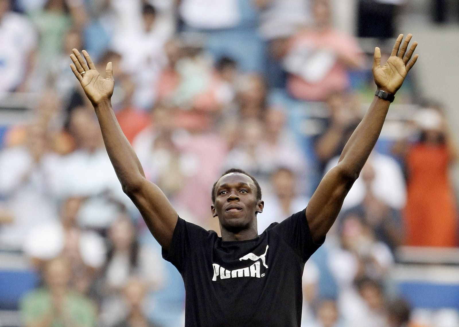 Usain Bolt saluda a los 80.000 aficionados reunidos en el Bernabéu para ver el Real Madrid-Deportivo con el que arrancaba la Liga 2009-2010.
