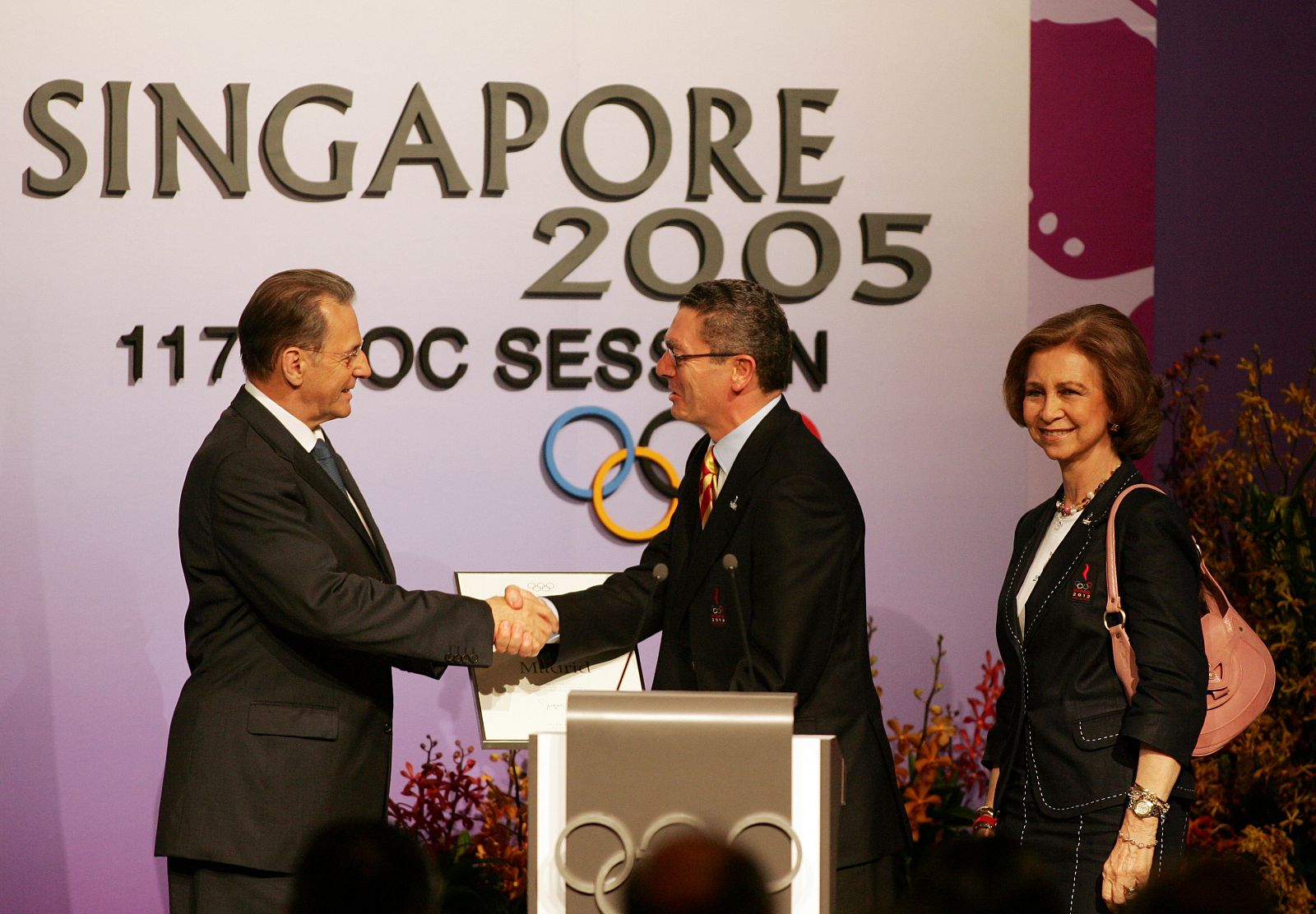 El presidente del COI, Jacques Rogge, saluda al alcalde de Madrid, Alberto Ruiz Gallardón, y a la reina Sofía hace cuatro años en Singapur.